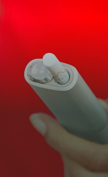 An IQOS ILUMA ONE device in a womans hand.